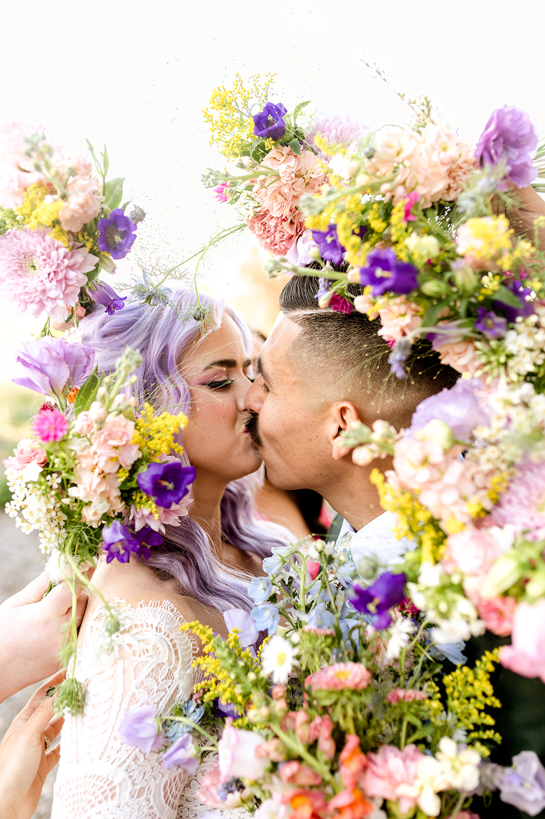 Cora and Gabriel sharing a close, colorful wedding moment