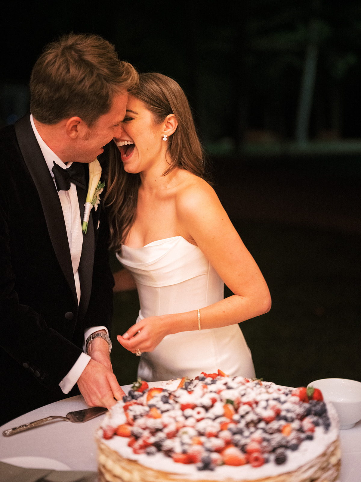Bride and groom happy cutting cake.