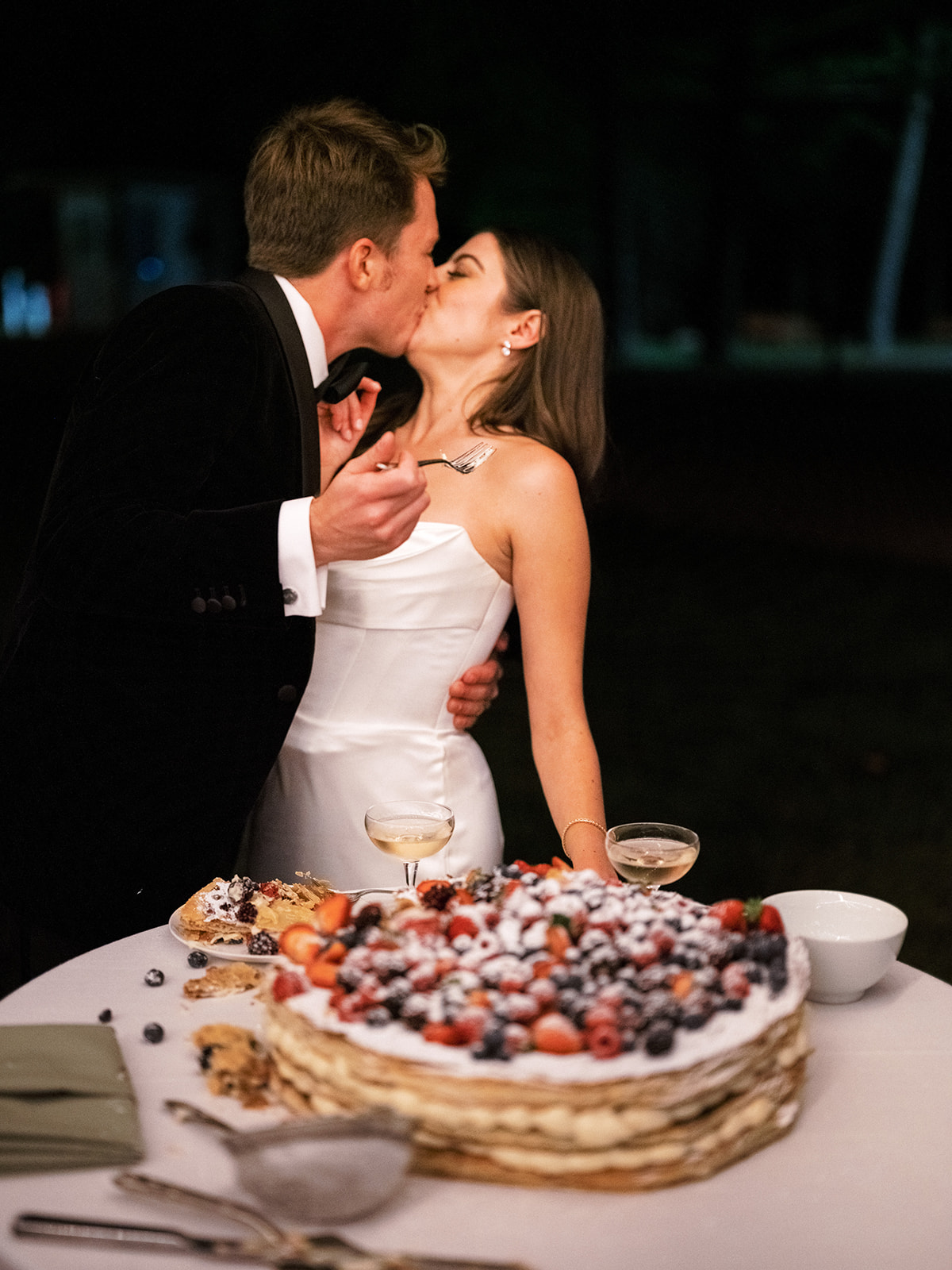 Bride and groom kissing after cutting cake.