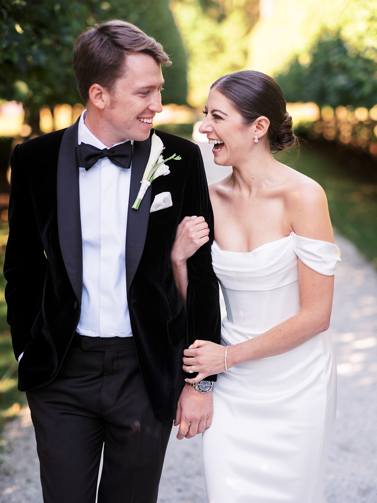 Bride and groom laugh and look at each other.