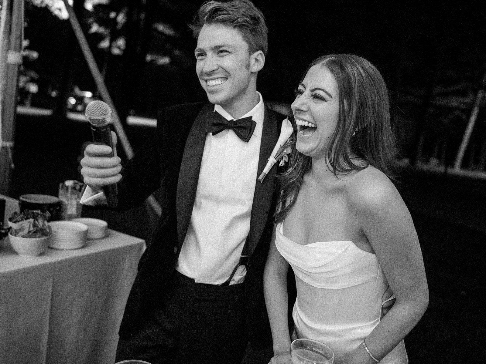 Bride and groom laughing late in reception.