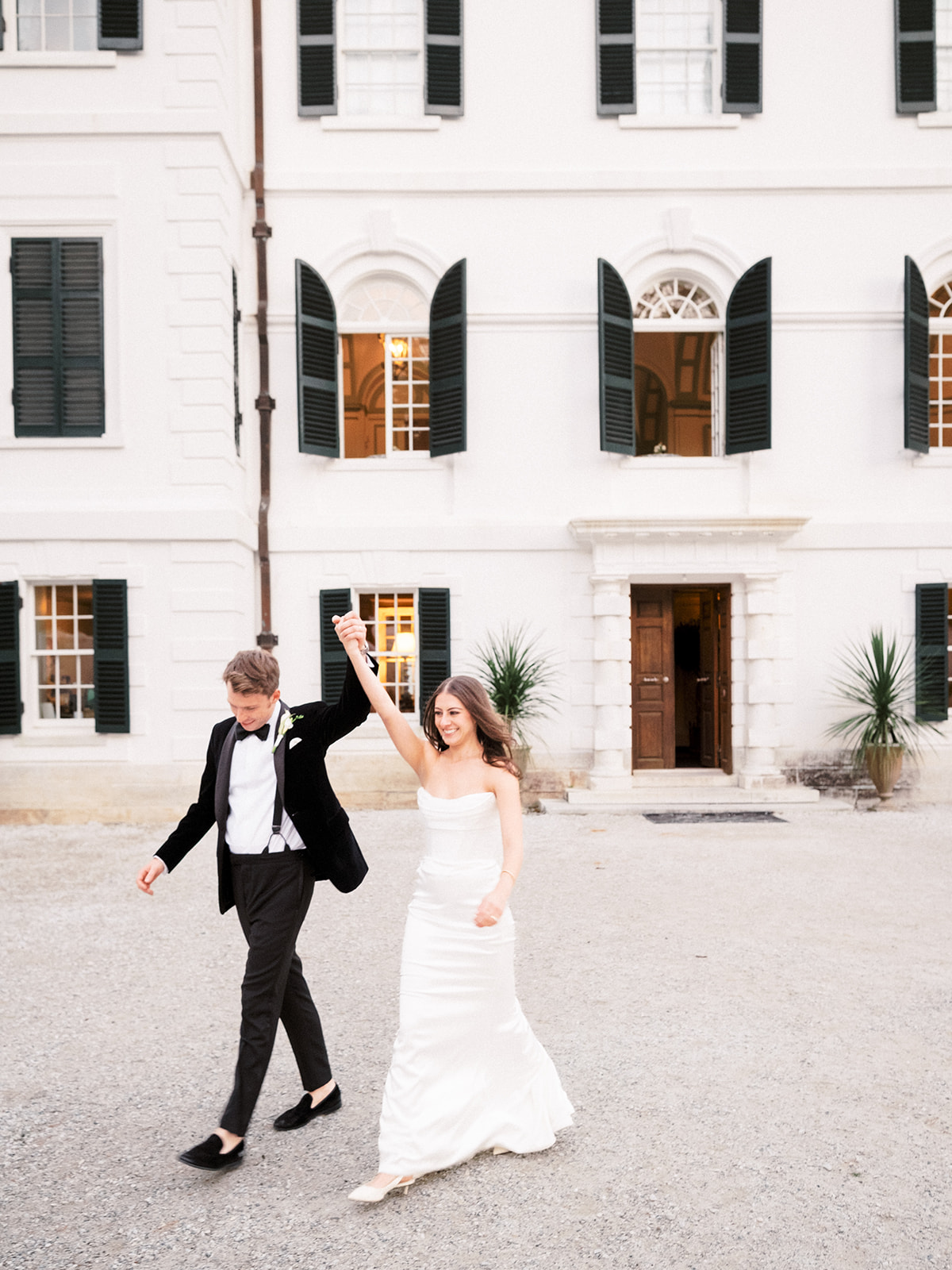 Bride and groom walk away from the building.