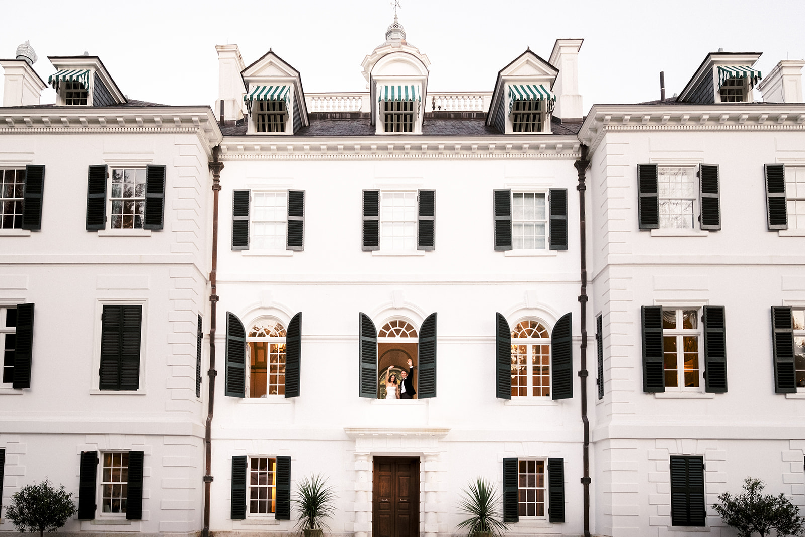 Bride and groom wave from the second floor of The Mount.