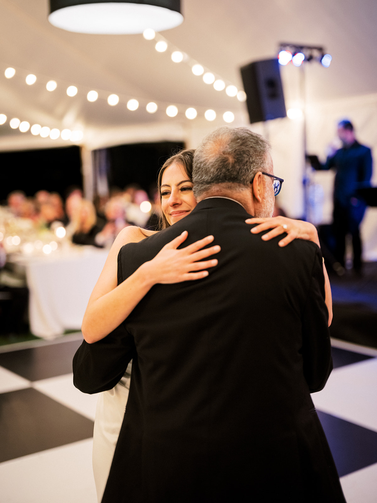 Bride hugs her dad during parent dances at the reception.