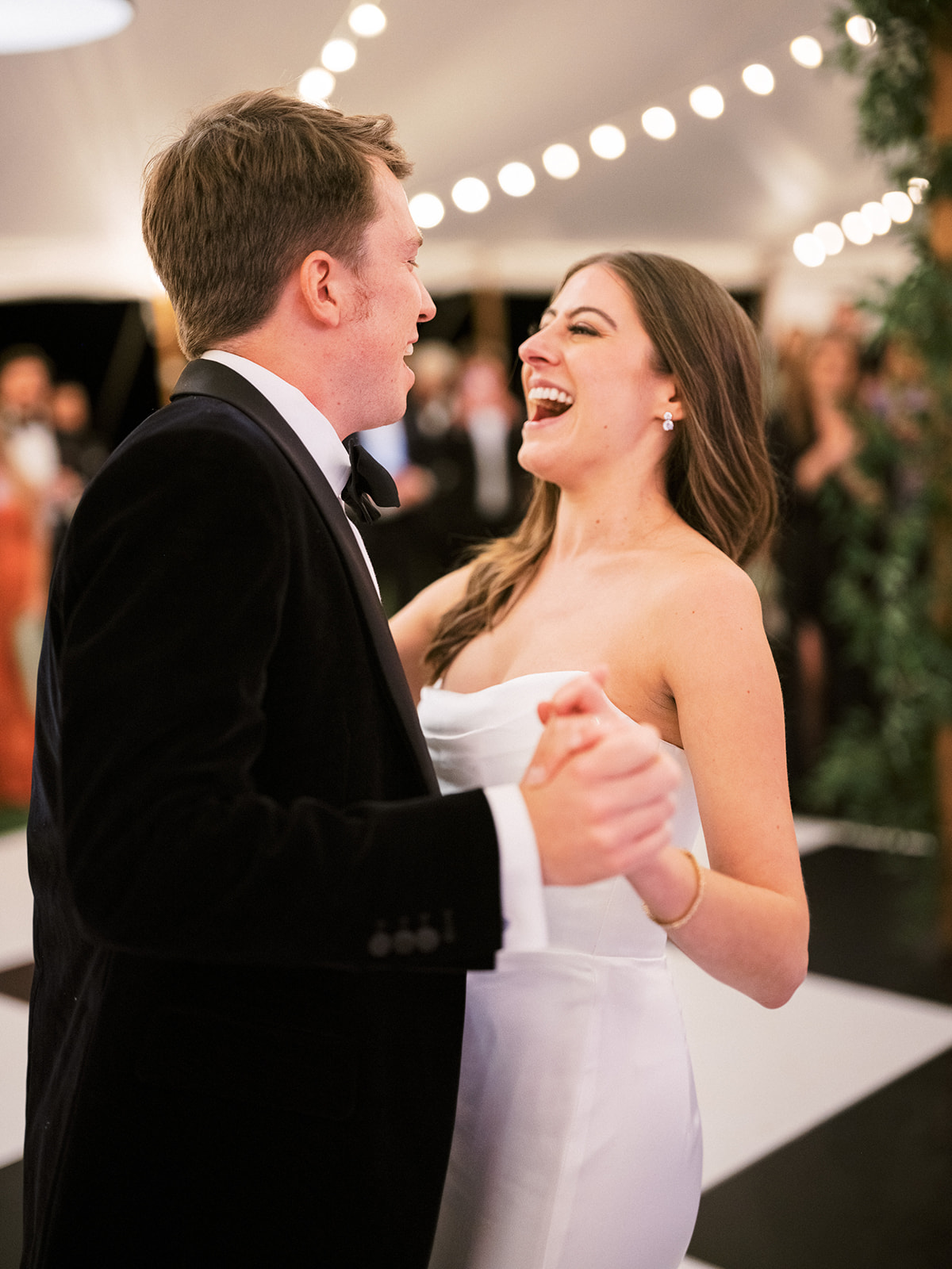 Close-up of bride and groom smiling at each other during their first dance under the canopy.