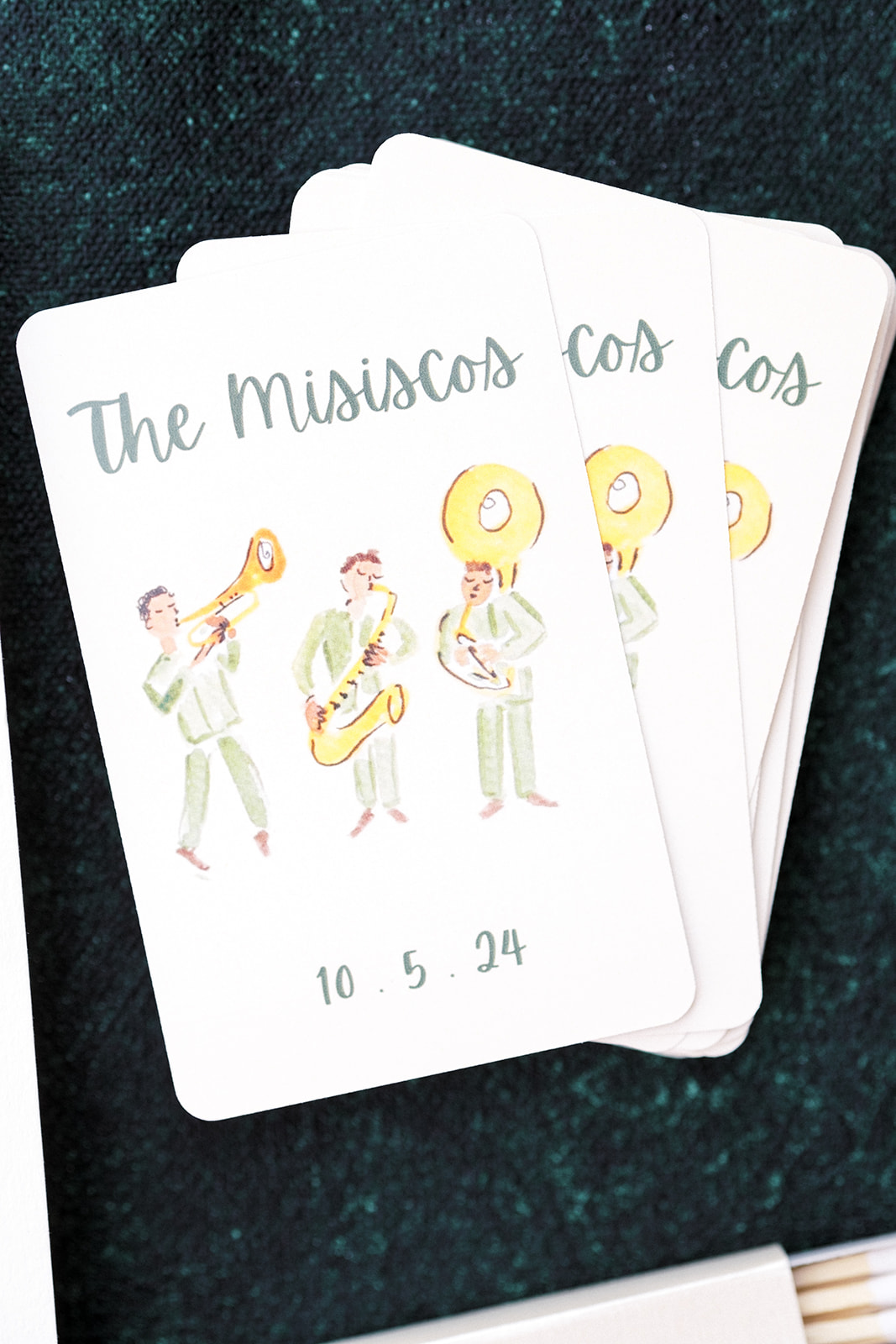 Close-up of custom illustrated wedding playing cards featuring wedding date and couple’s monogram