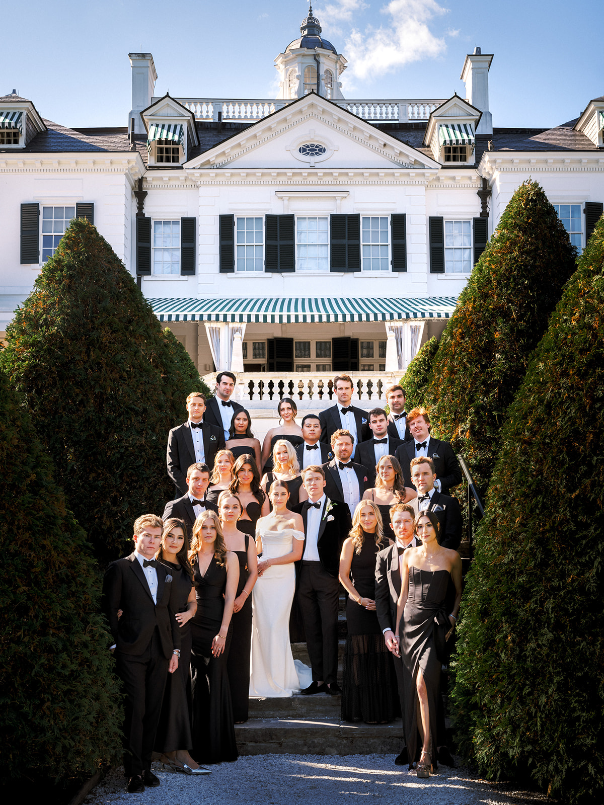 Full bridal party portrait in front of The Mount estate during classic black-tie wedding