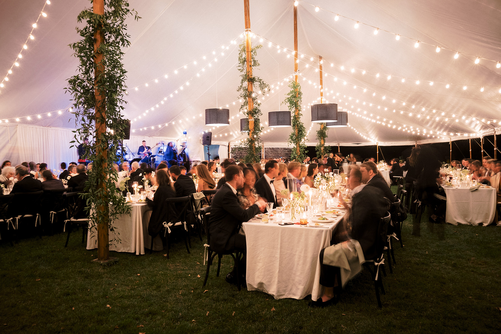String lights illuminating the dinner tables as guests enjoy the candlelit meal.