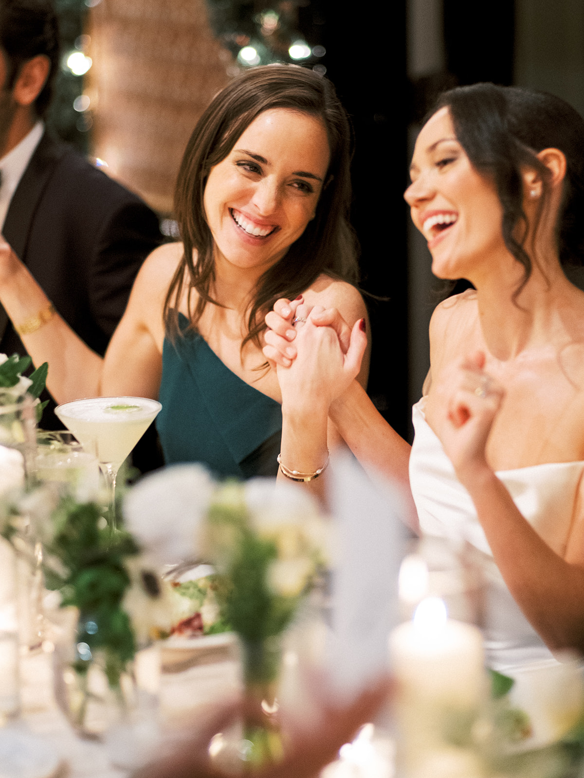 Bride and friend have a moment at tables in Baron's Cove.