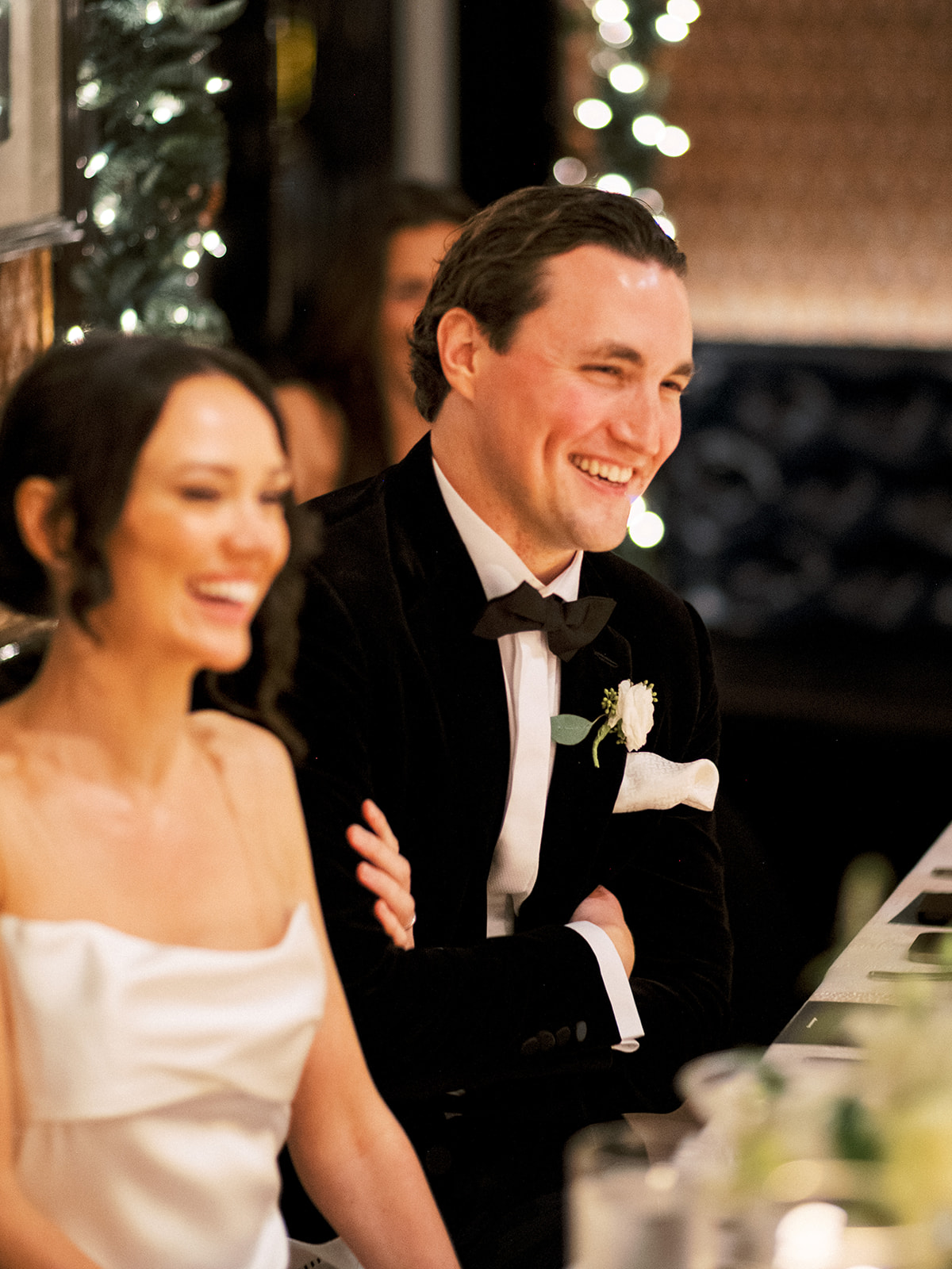 Bride and groom clinking glasses in a toast at the sweetheart table.