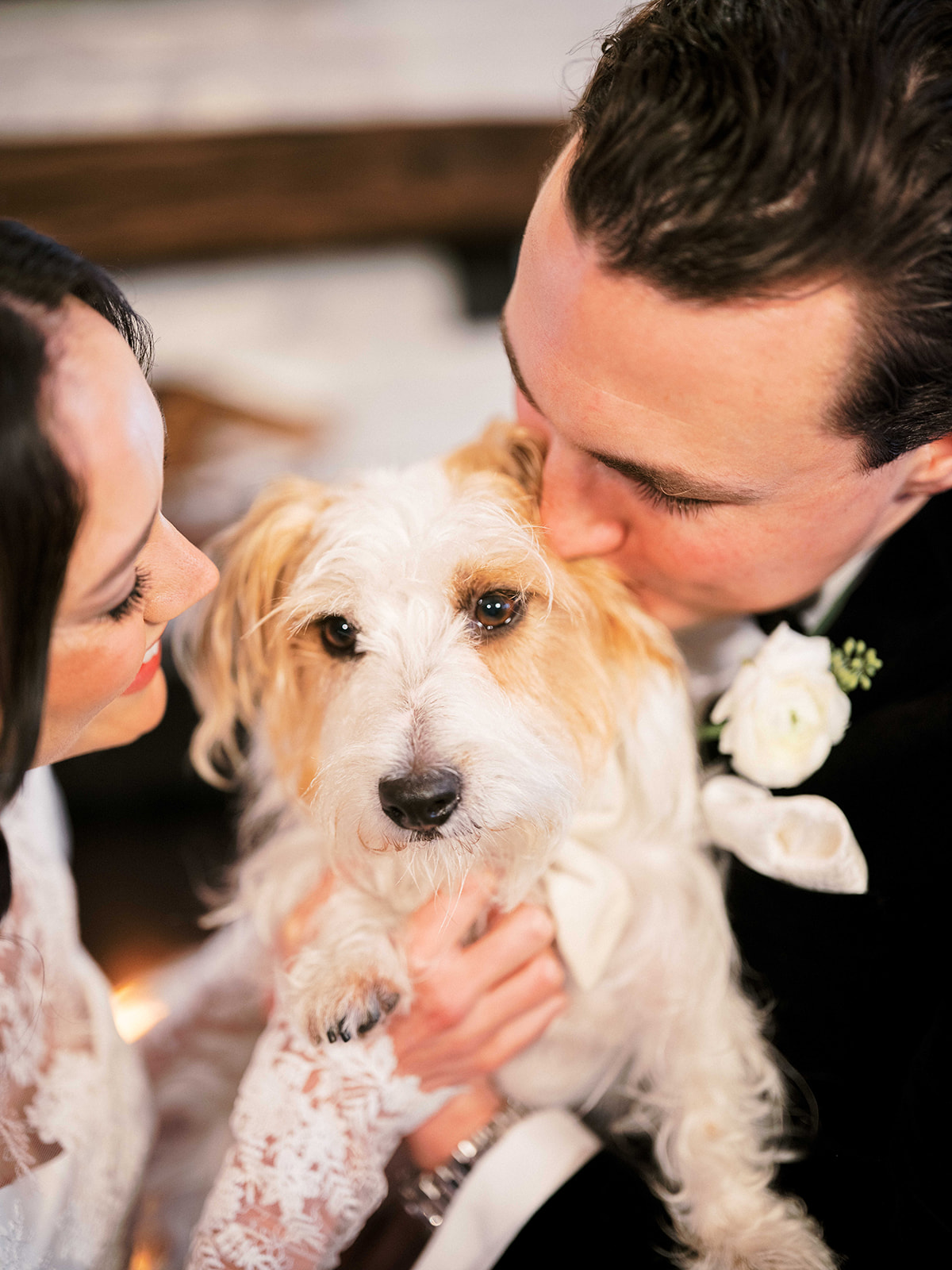 Bride and groom embrace their dog.