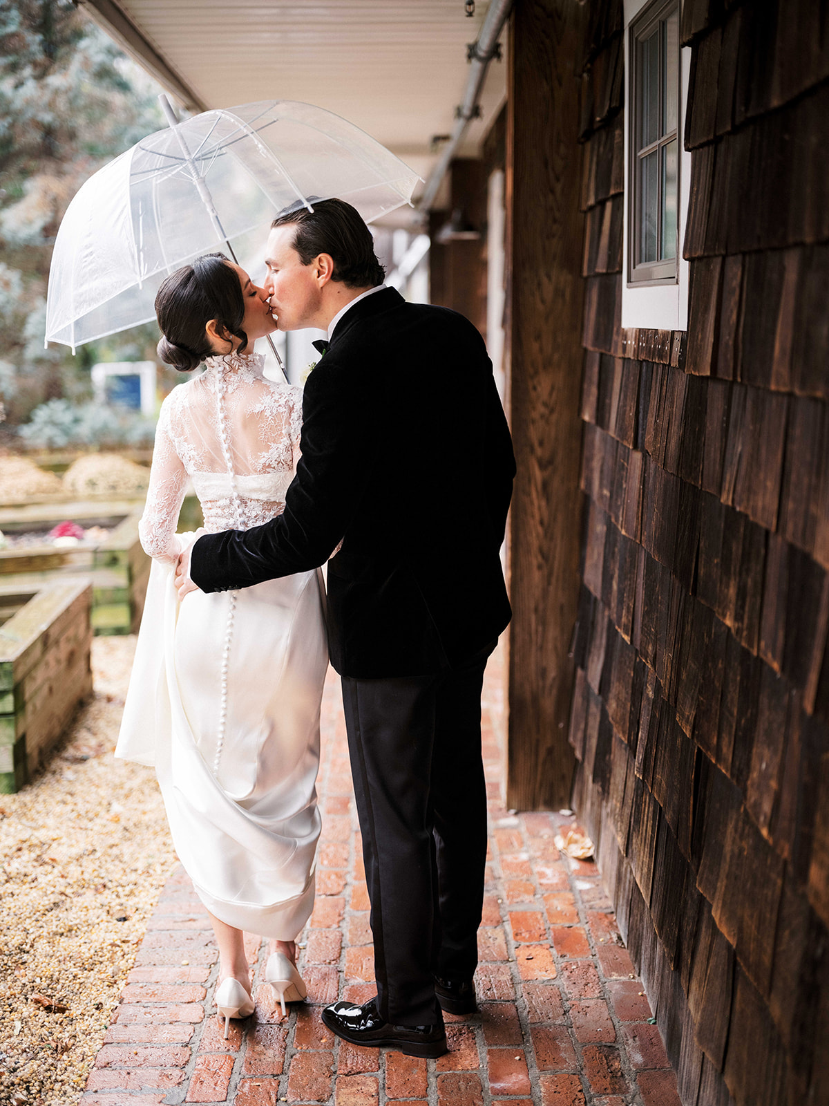 Bride and groom sharing a private moment under an umbrella before the ceremony.