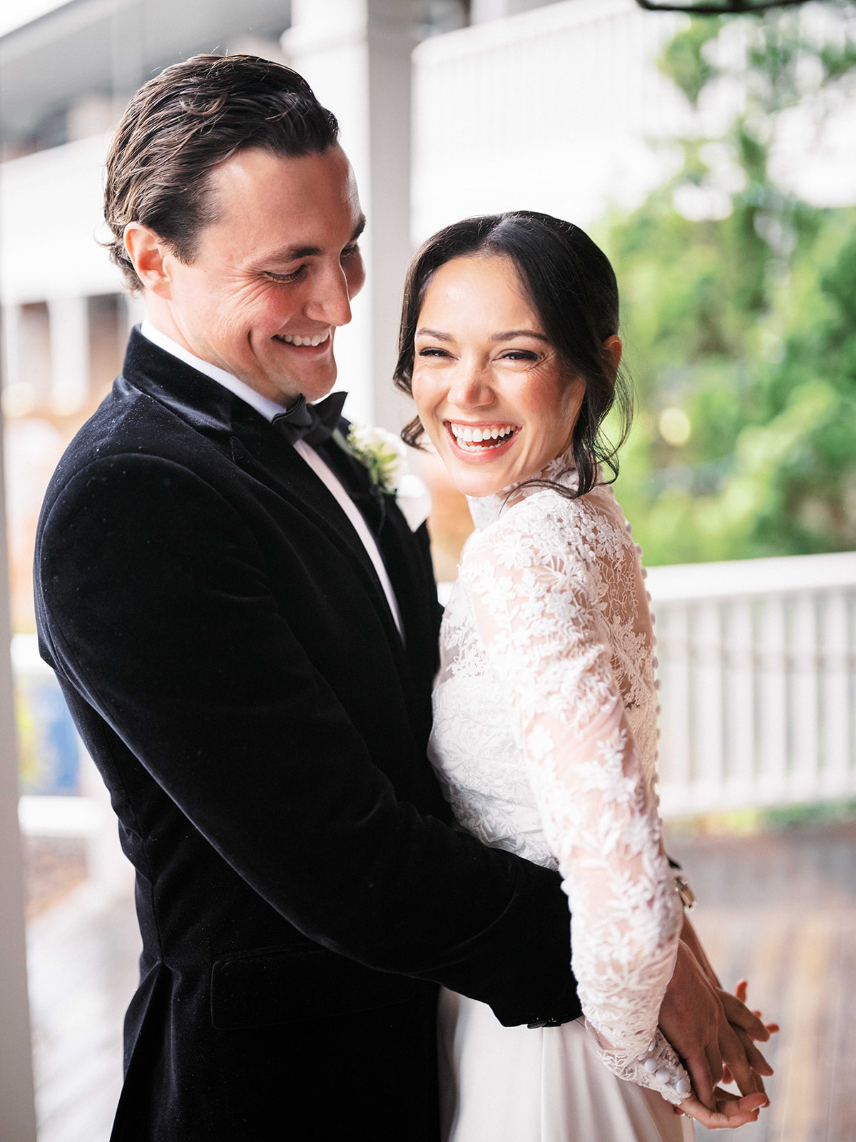 Bride and groom smiling at one another during their first look outside Baron's Cove.