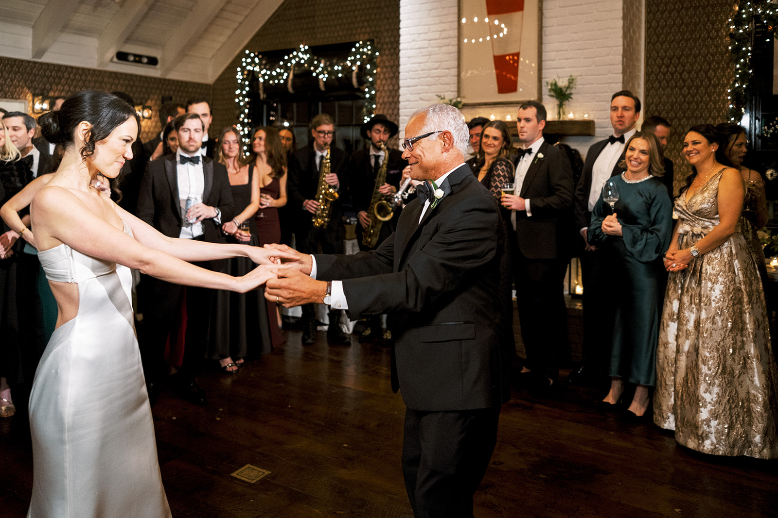 Bride and her dad on the dance floor, surrounded by cheering guests.