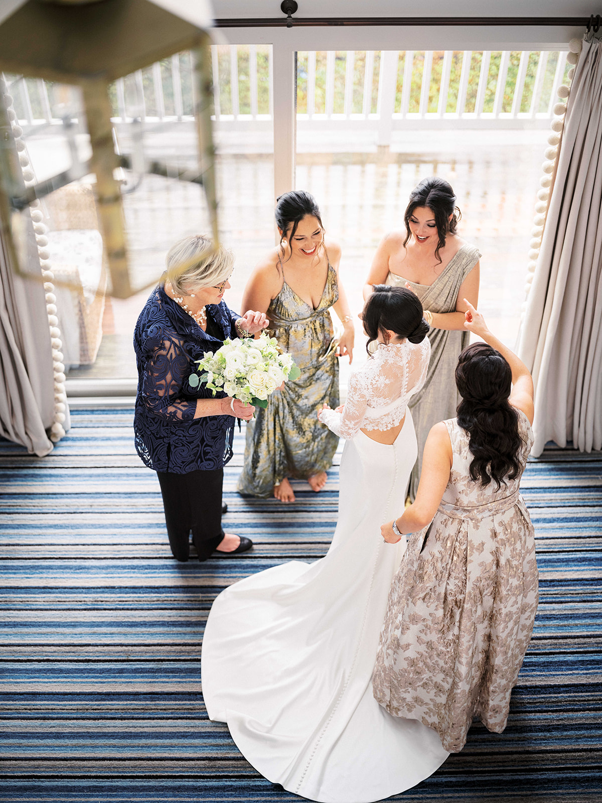 Bride smiling with family in bridal suite at Baron's Cove in Sag Harbor.