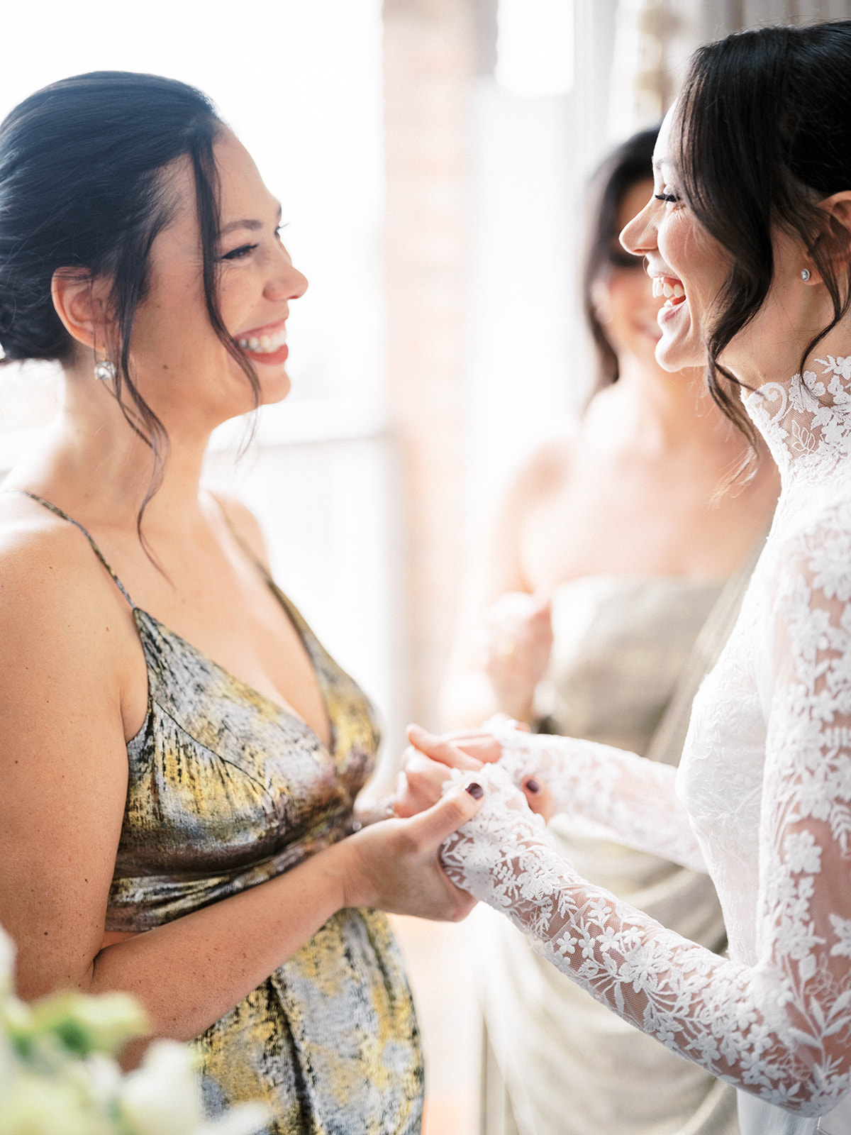 Candid moment of the bride laughing with bridesmaids during prep at Baron's Cove.