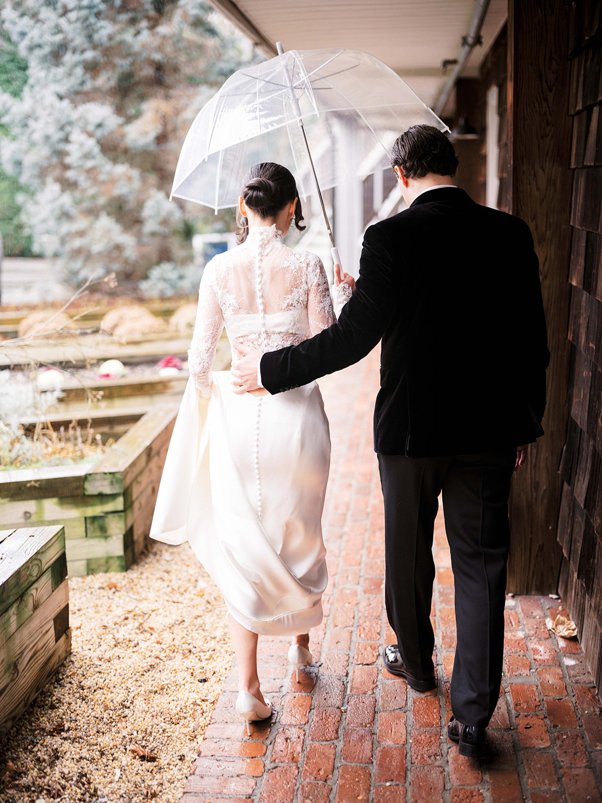 Candid moment of the couple holding hands and walking down the path.