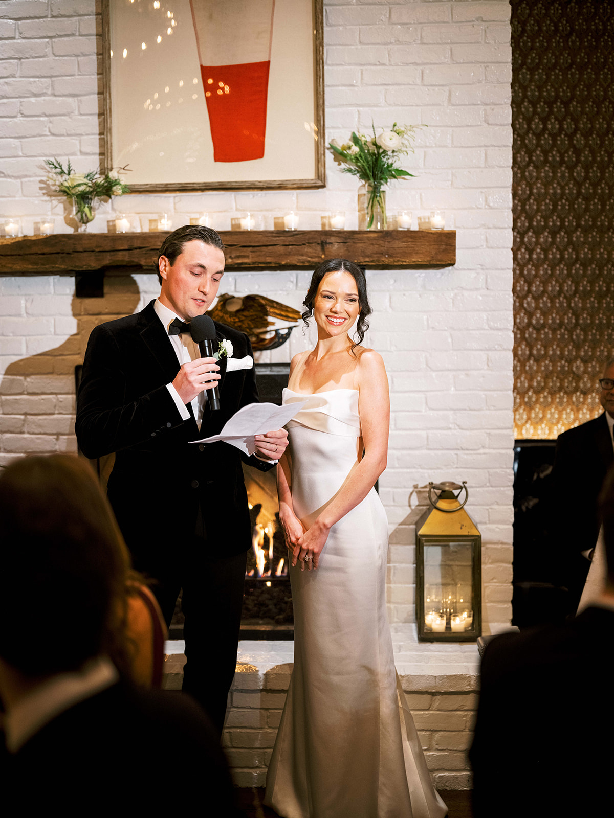 Couple laughing during speech with string lights above.