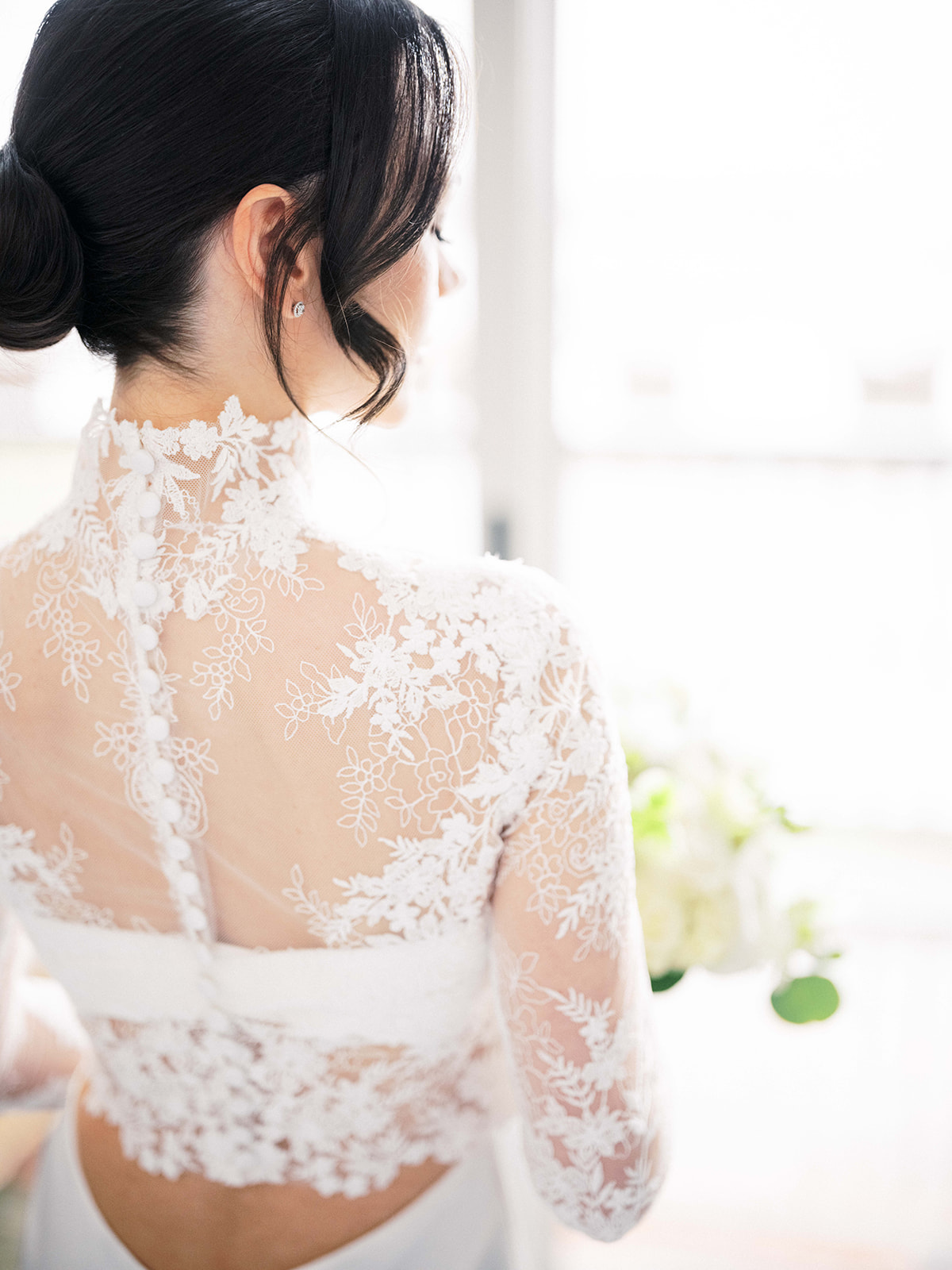 Detail shot of bride's lace dress and bouquet held gently in her hands.