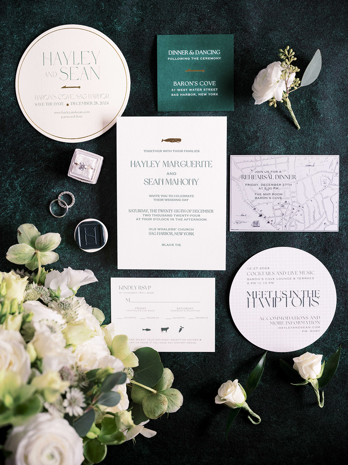 Flatlay of elegant wedding invitation suite with floral details at Baron's Cove.