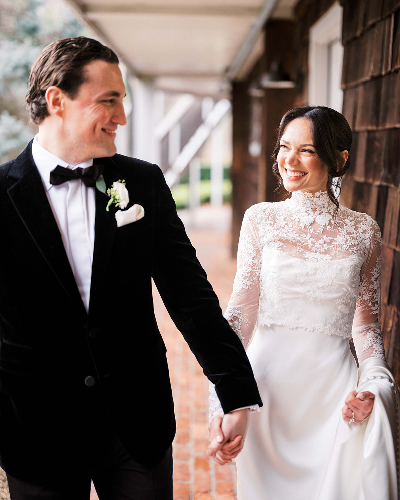 Groom and bride looking at each other as they walk.