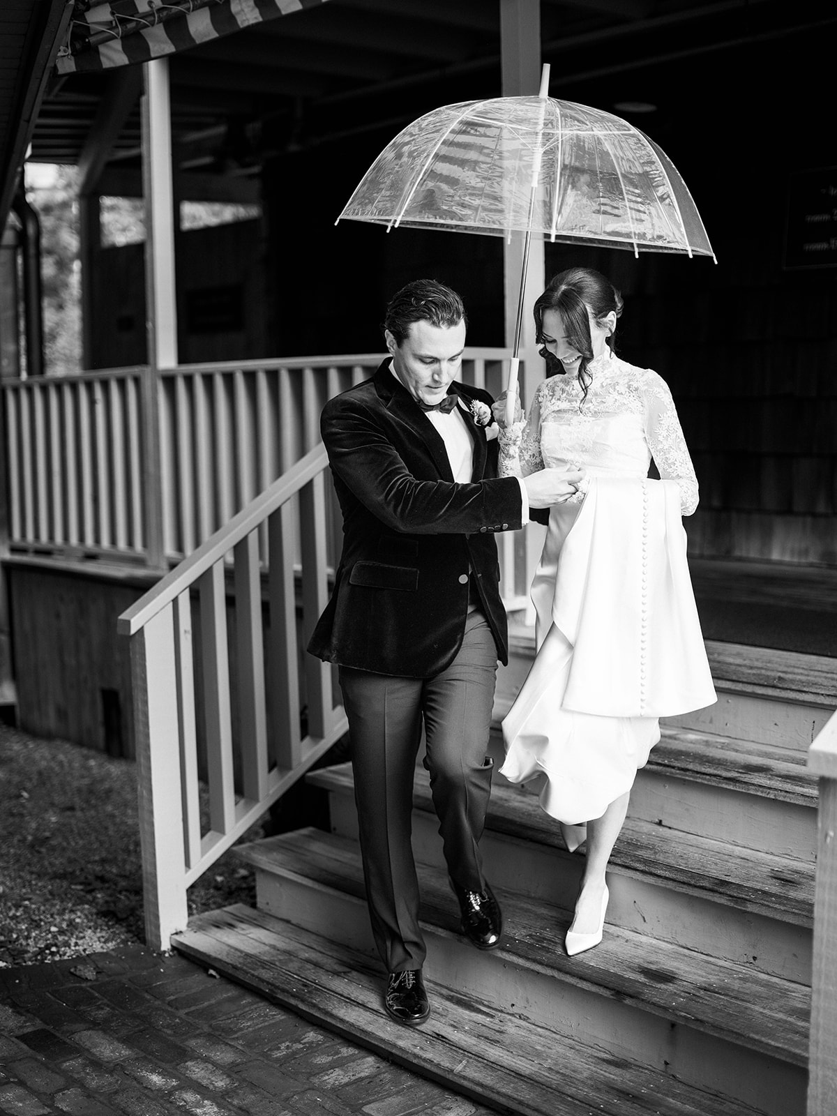 Groom helps bride down stairs at Baron's Cove.