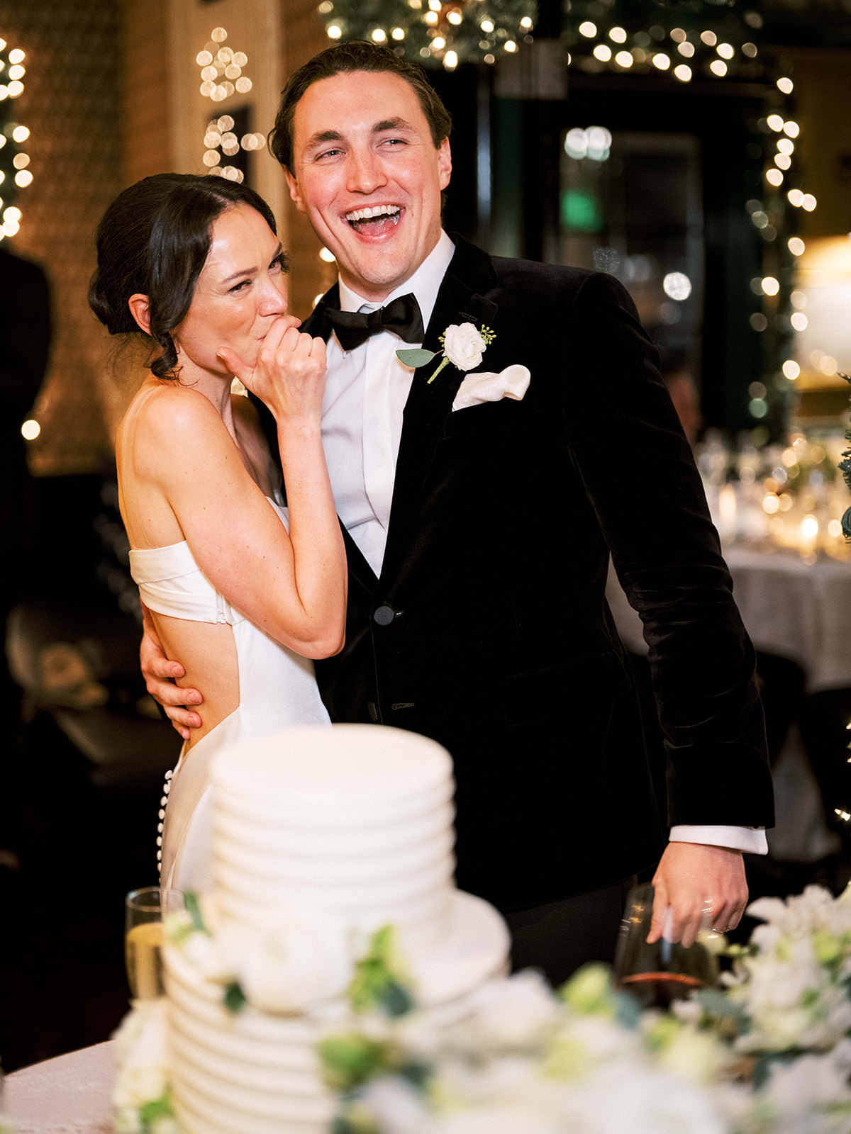 Groom holding a slice of cake and smiling during cake cutting at Baron's Cove.