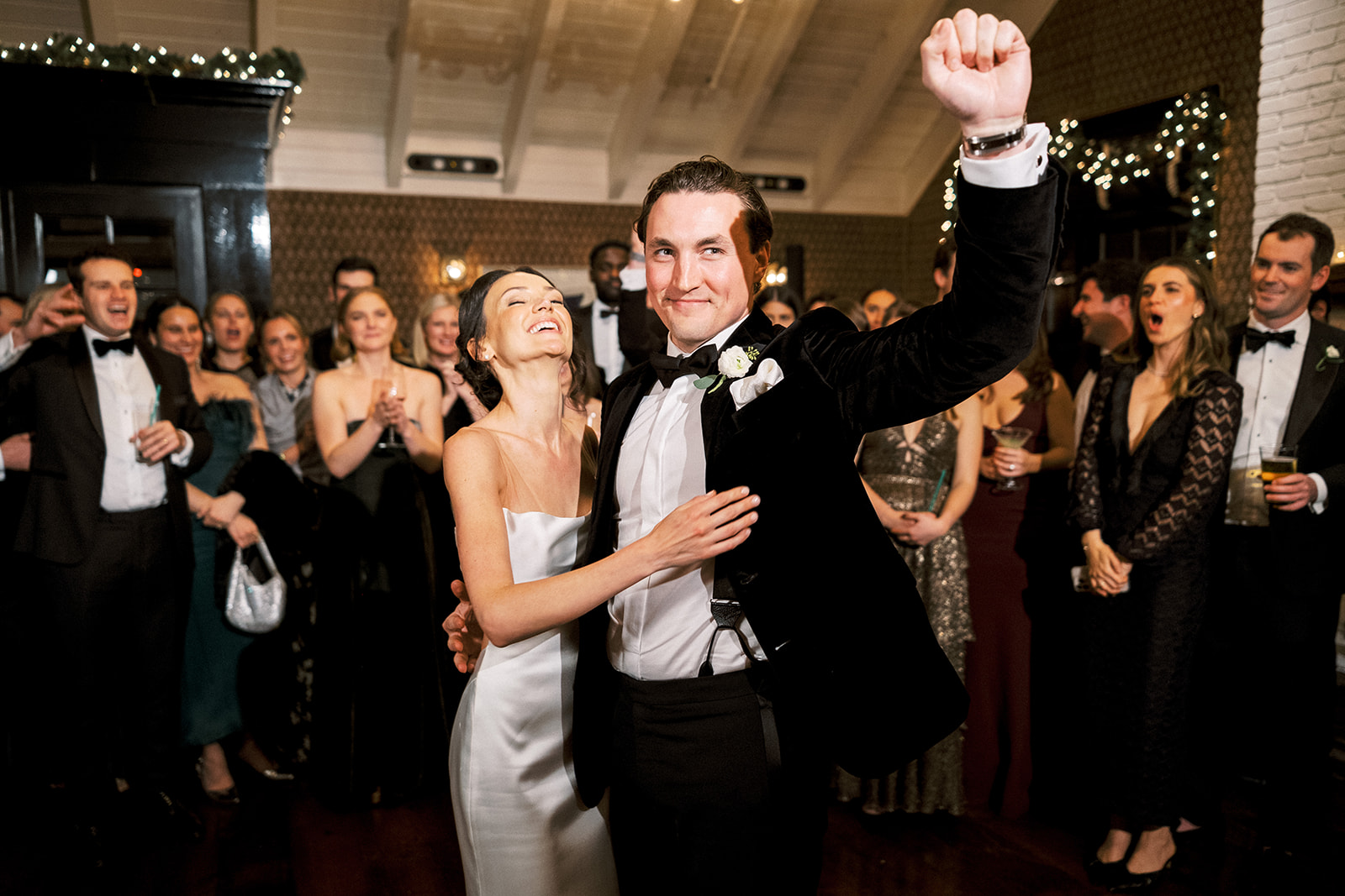 Guests cheering as couple performs a fun dance move together.