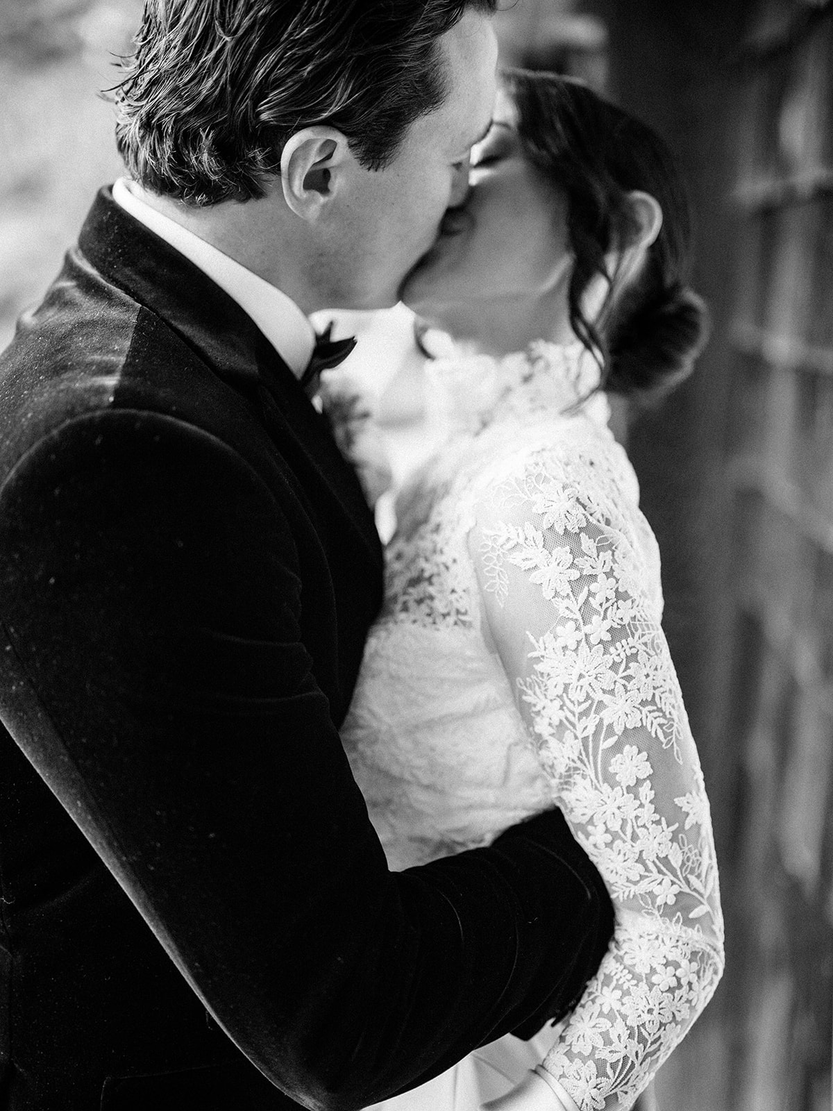 The couple sharing a kiss surrounded by greenery in black and white at Baron's Cove.