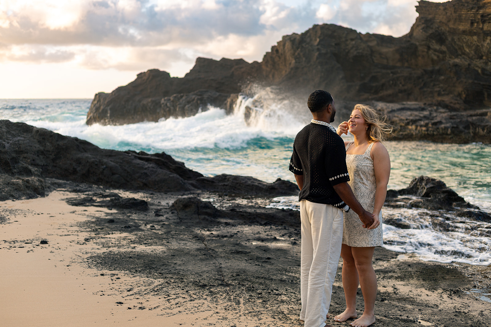 Romantic couple's session at Halona Beach Cove with dramatic morning light and rugged lava rocks.
