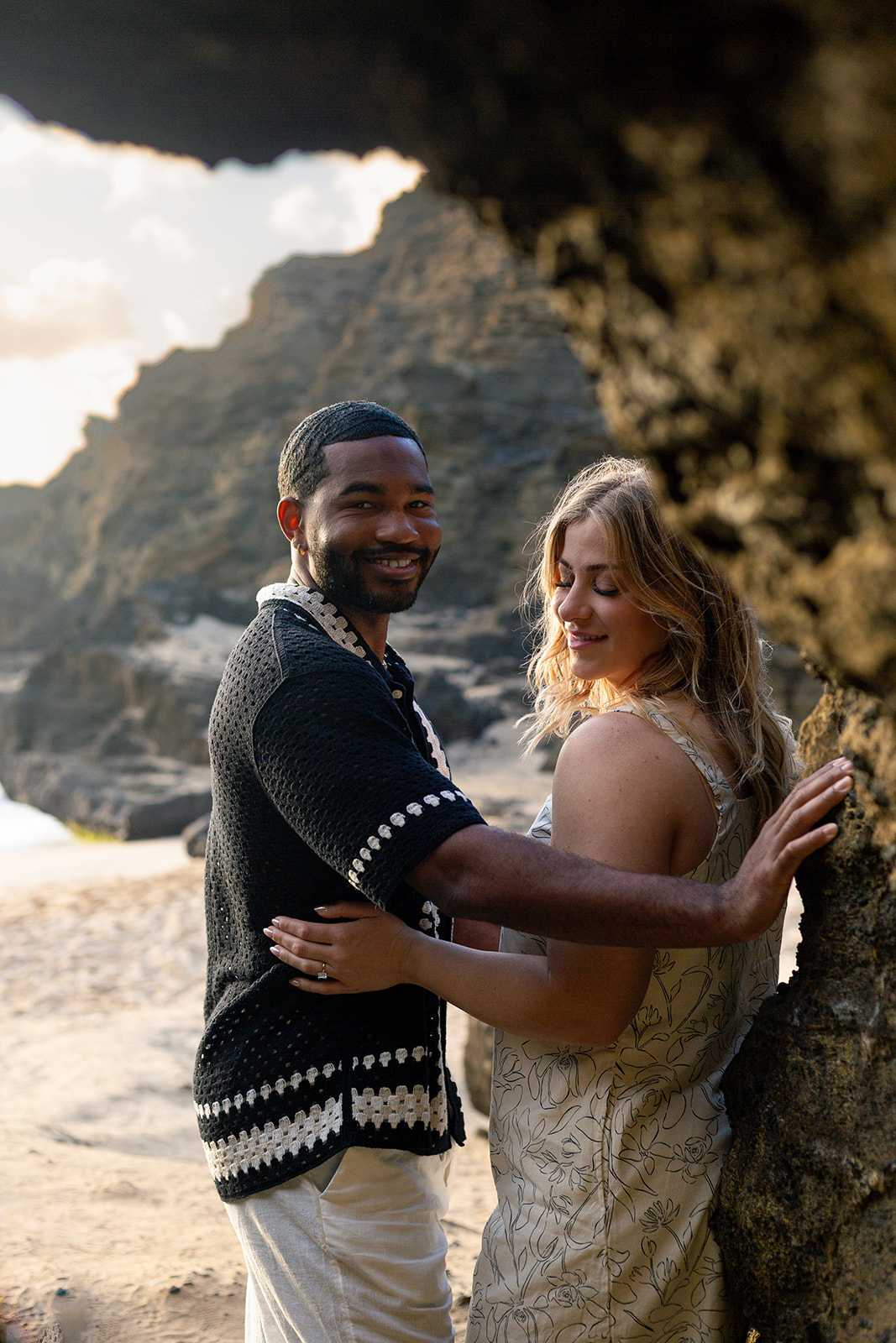 Romantic couple's session at Halona Beach Cove with dramatic morning light and rugged lava rocks.