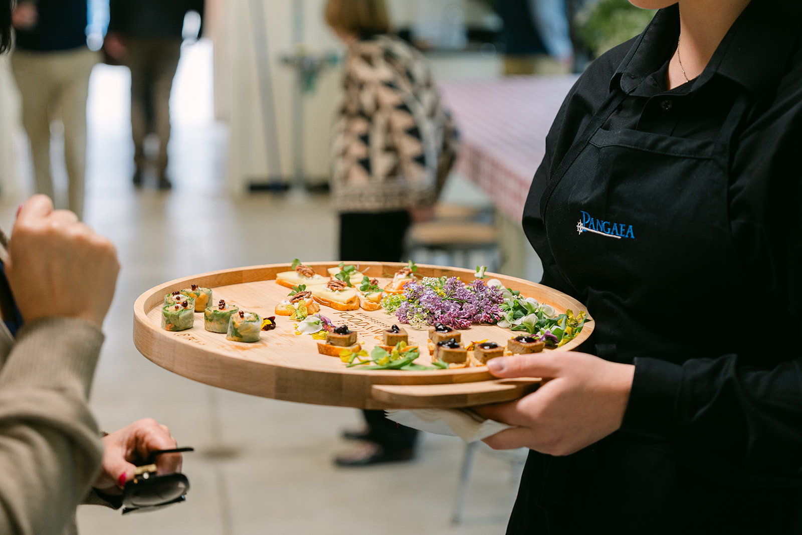 A server carrying a board of small bites